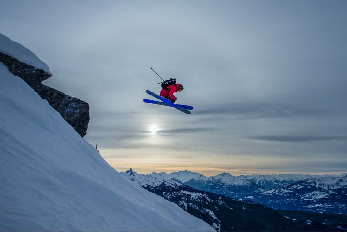 Kieran Nikula cliff dropping on his skis at sunset