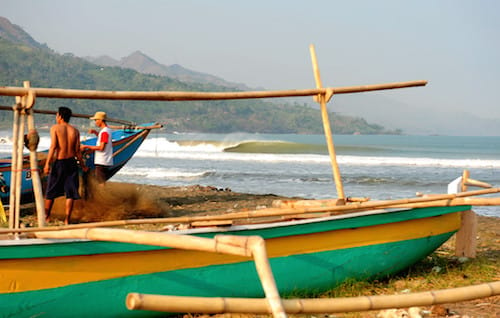 Boats on the beach in Java surf